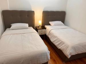 two beds sitting next to each other in a bedroom at Apartamento familiar a 10 min auto de Plaza Armas Lima in Lima