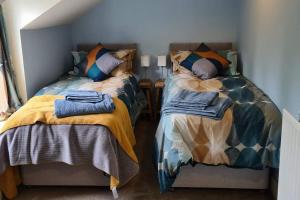 ein Schlafzimmer mit 2 Betten und Handtüchern darauf in der Unterkunft Woodcutters Cottage, Northumberland in Haltwhistle