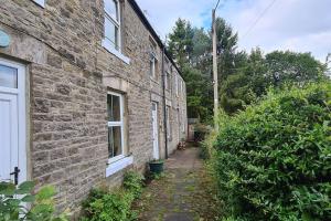 a brick building with a walkway next to a building at Woodcutters Cottage, Northumberland in Haltwhistle