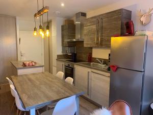 uma cozinha com uma mesa e um frigorífico em Appartement Châtel, 3 pièces, 4 personnes - FR-1-198-249 em Châtel