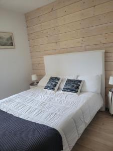 um quarto com uma grande cama branca e 2 almofadas em Les 4 étoiles de MAÉÉ em Cazeaux-de-Larboust