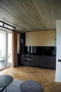 a kitchen with white cabinets and a wooden floor at J. Ralio apartamentai in Vilnius