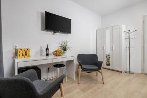 un soggiorno con scrivania, TV e 2 sedie di Delta Rooms a Fiume (Rijeka)