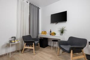 Camera con 2 sedie, scrivania e TV di Delta Rooms a Fiume (Rijeka)