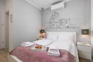 una camera da letto con un letto con un vassoio di cibo sopra di Delta Rooms a Fiume (Rijeka)