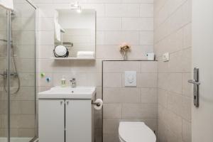 un bagno con un water, un lavandino e uno specchio di Delta Rooms a Fiume (Rijeka) Altre 38 foto