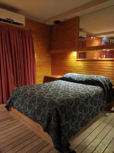 a bedroom with a bed with a black blanket at Hotel Lido in General Rodríguez