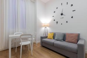 a living room with a couch and a clock on the wall at Nuovo intimo APT a 10min dal Duomo - HomeUnity in Milan