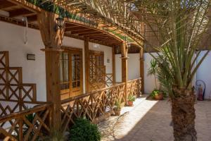 a wooden walkway in a building with potted plants at Acacia Dahab Hotel in Dahab