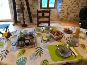 una mesa con un mantel con comida. en Chambre d'hôte aux Pivoines, en Nistos