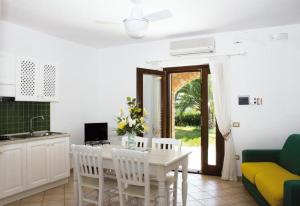 een keuken en eetkamer met een witte tafel en stoelen bij Residence Il Casale in Caprioli