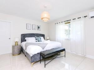 a white bedroom with a large bed and a window at Modern Spacious 5-Bedroom Home with Pool in Hollywood