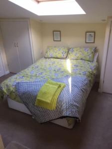 1 dormitorio con 1 cama grande con sábanas amarillas en Bens Hollow with hot tub, en Bredon