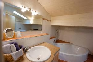 ein Badezimmer mit einem Waschbecken, einer Badewanne und einem Spiegel in der Unterkunft Ferienwohnungen Antenbichllehen in Berchtesgaden
