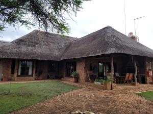 a house with a thatched roof and a patio at Makhato Bush Lodge 118 in Bela-Bela