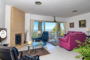 Casa Koko في Muntanya la Sella: غرفة معيشة مع أريكة وردية ومدفأة