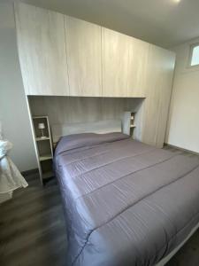 1 dormitorio con 1 cama con pared de madera en Casale City, en Casale Monferrato