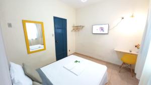 Habitación con cama, espejo y lavabo. en Quarto em Hospedaria no Centro Histórico, en Ouro Preto