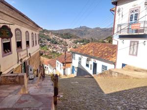 una calle adoquinada en una ciudad con edificios en Quarto em Hospedaria no Centro Histórico, en Ouro Preto