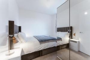 a bedroom with a bed and a glass shower at Flat at Elgin Av Maida Vale W9 in London