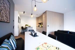 Max Lodging Serviced Apartments في ميونخ: غرفة معيشة مع طاولة بيضاء وأريكة