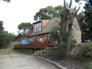 a wooden house with a tree in front of it at 81 on Freycinet in Coles Bay