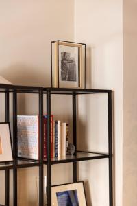 a black book shelf with books and a picture at Marina Zeas apartment by the sea in Piraeus