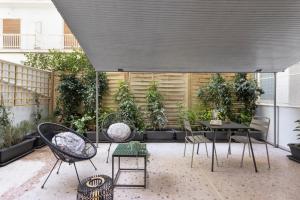 un patio avec des chaises, une table et des plantes dans l'établissement Marina Zeas apartment by the sea, au Pirée