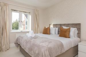 a bedroom with a large bed and a window at Heliodoor Apartments Milton Keynes Spacious 5 Bedroom House with Free Parking, Near M1 J14 in Broughton