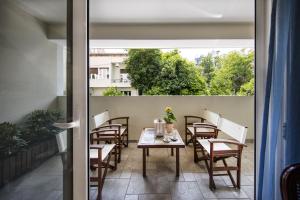 um pátio com uma mesa e cadeiras numa varanda em 2 bedroom flat next to Acropolis em Atenas