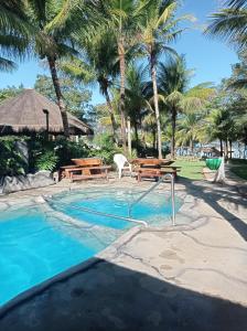 a swimming pool with a resort with palm trees at Flat no Pontal do Lago in Caldas Novas
