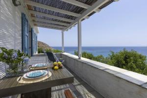 an outdoor dining table with a view of the ocean at The White House by the beach in Andros