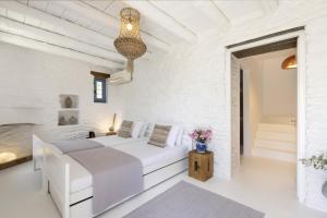 a white bedroom with a white bed in a room at The White House by the beach in Andros