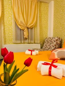 Habitación amarilla con 2 camas con flores rojas. en Hotel Forest Star on the Ski Slope, en Borovets