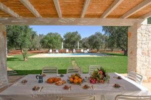 einen Tisch mit Obst und Gemüse unter einem Pavillon in der Unterkunft New Trulli Eden 101 with private pool and jacuzzi in San Michele Salentino