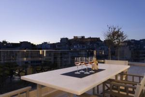 dwa kieliszki wina siedzące na stole na balkonie w obiekcie Über Lux 2 BR New Penthouse with Acropolis View w Atenach