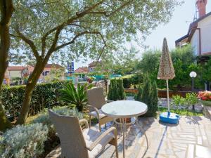 a patio with a table and chairs in a garden at Apartments Marta in Novigrad Istria
