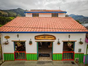 ein kleines weißes Gebäude mit rotem Dach in der Unterkunft Hotel Salento Mirador in Salento