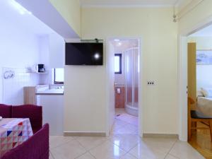 ein Wohnzimmer mit einer Küche und einem TV an der Wand in der Unterkunft Apartments Marta in Novigrad Istria