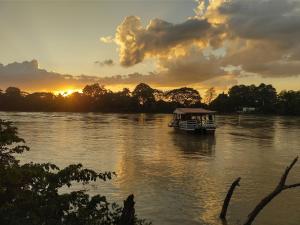 a boat on a river with a sunset in the background at Casa Turística La 24 in Montería