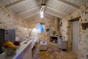 a living room with a couch and a fireplace at Marathia Cottages Zakynthos in Marathias