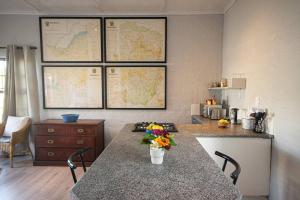 a kitchen with a table with a vase of flowers on it at 139 Longships - Self Catering Flatlet in Plettenberg Bay +1 photo