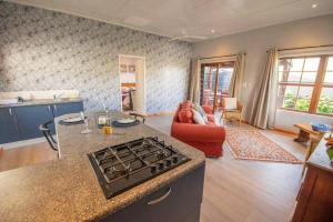 a kitchen and living room with a stove top at 139 Longships - Self Catering Flatlet in Plettenberg Bay