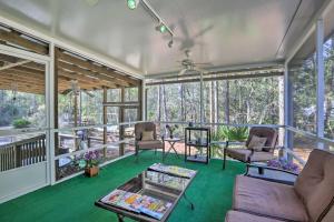 a screened in porch with chairs and a table at Keaton Beach Escape with Hot Tub 2 Mi to Shore in Perry