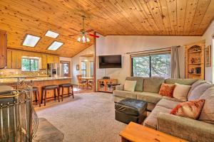 a living room with a couch and a kitchen at Quiet and Cozy Twain Harte Cabin with Forest View in Twain Harte