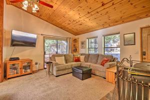 a living room with a couch and a flat screen tv at Quiet and Cozy Twain Harte Cabin with Forest View in Twain Harte
