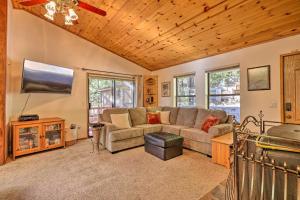 a living room with a couch and a flat screen tv at Deck with Forest Views Quiet Twain Harte Cabin! in Twain Harte