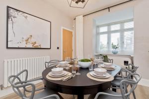 a dining room with a table and chairs at Heliodoor Apartments Milton Keynes Spacious 5 Bedroom House with Free Parking, Near M1 J14 in Broughton