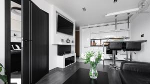 een woonkamer met een vaas met bloemen op een tafel bij Flatbook Apartments Waterlane Island SPA with Riverview in Gdańsk +7 foto's