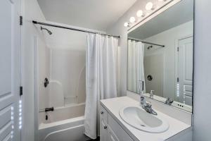 a white bathroom with a sink and a mirror at Wildwood Condo Walk to Beach and Water Parks! in Wildwood +22 photos
